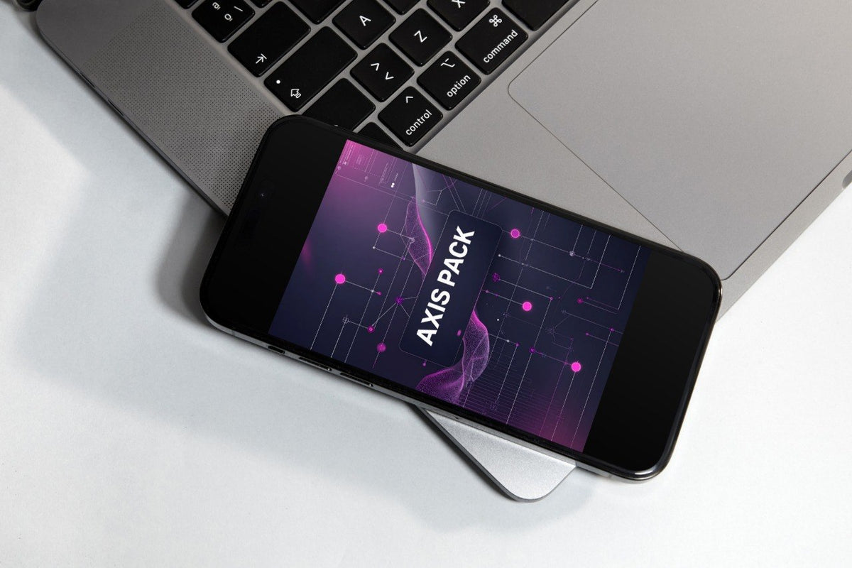A smartphone lying diagonally on a white surface next to an open silver laptop, with the phone screen displaying the text 'AXIS PACK' over a purple and black abstract graphic.