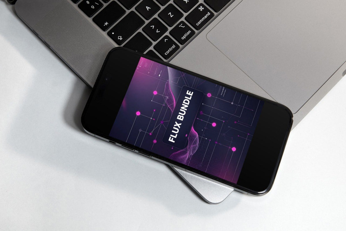 A black smartphone lying diagonally on a white surface, partially covering a silver laptop. The phone screen displays a dark purple and pink abstract graphic with the text 'FLUX BUNDLE'.